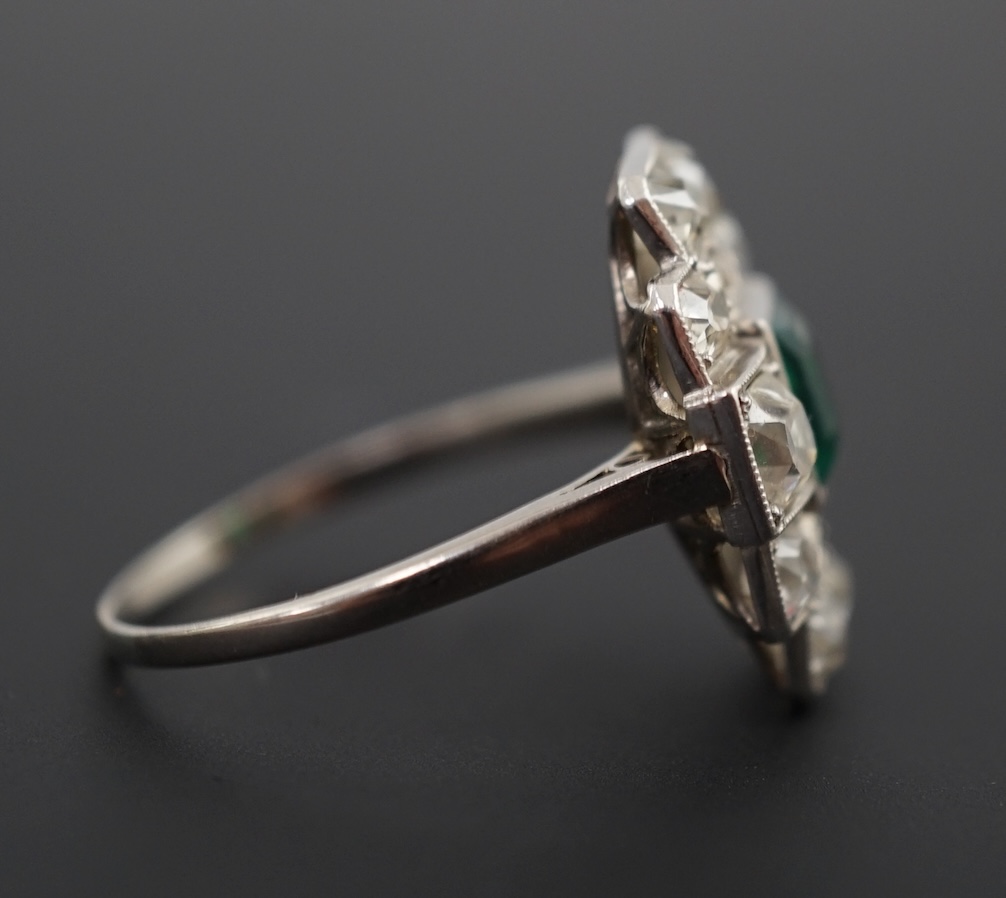 An early to mid 20th century white gold?, emerald and diamond cluster set stepped oval dress ring